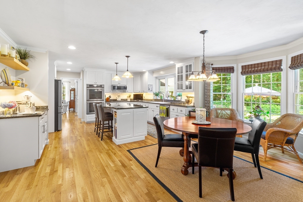 28 Broken Tree Road Medway, MA 02053 - Photo 8 of 42 a dining hall with stainless steel appliances kitchen island granite countertop a table chairs and a wooden floor