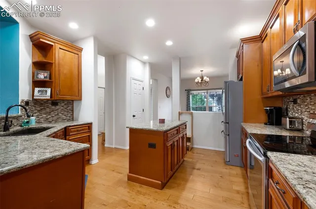 a kitchen with stainless steel appliances granite countertop a stove a sink and a refrigerator