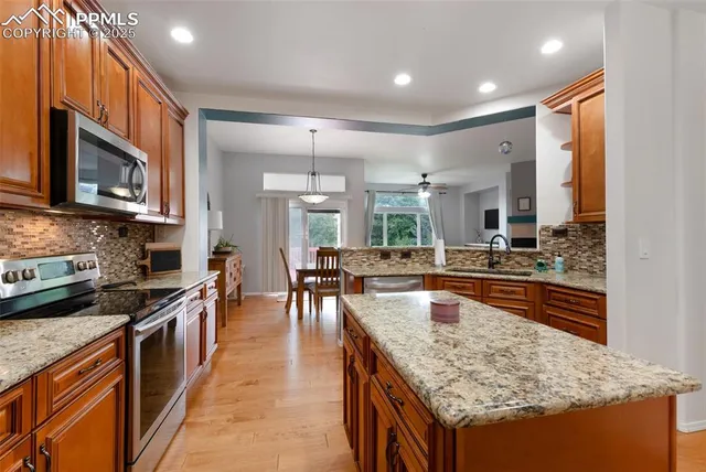 a kitchen with stainless steel appliances granite countertop sink stove top oven and microwave