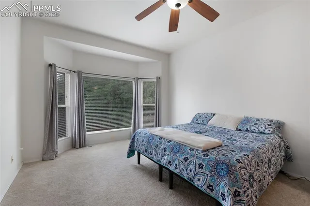 a bed sitting in a bedroom next to a window