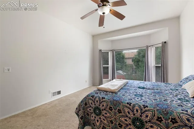 a bedroom with a bed and a large window