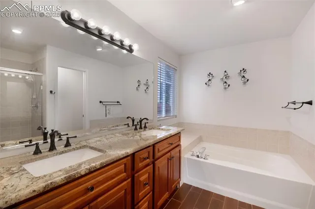 a bathroom with a granite countertop double vanity sink and mirror with bathtub
