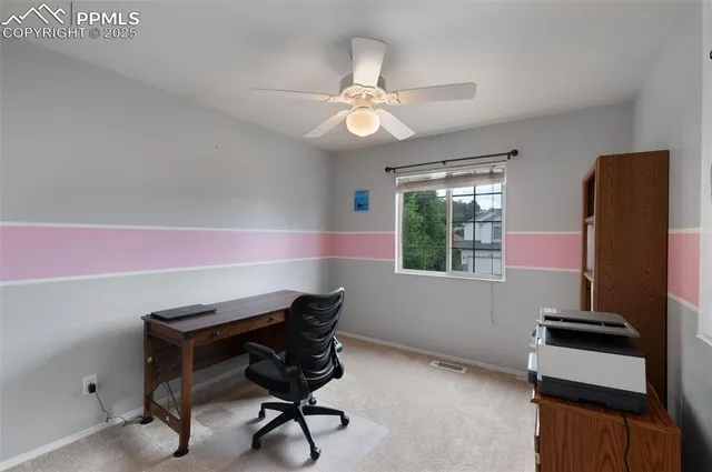 a view of a workspace with furniture and a window