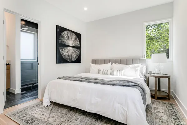 a bedroom with a bed and a painting on the wall