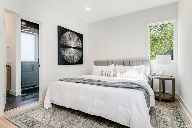 a bedroom with a bed and a painting on the wall