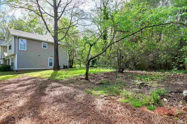 a view of a house with backyard and tree