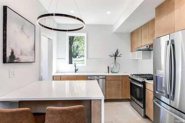 a kitchen with stainless steel appliances a stove a sink and a refrigerator