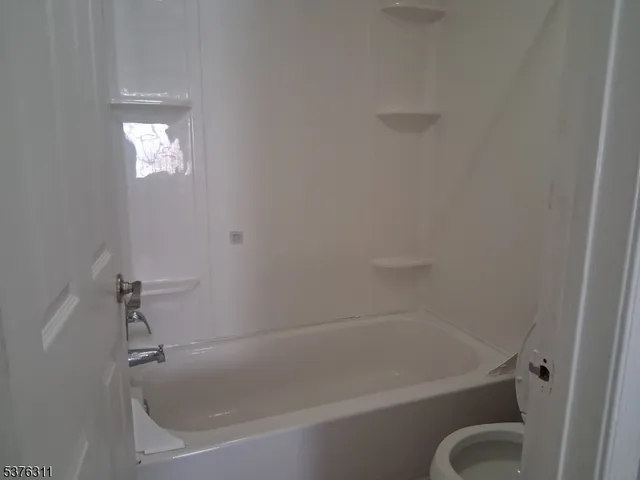 a white bath tub sitting next to a shower