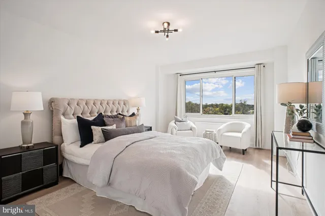 a bedroom with two beds and large windows