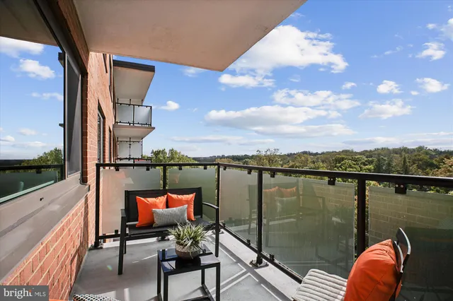 a balcony with couple of chairs and wooden floor