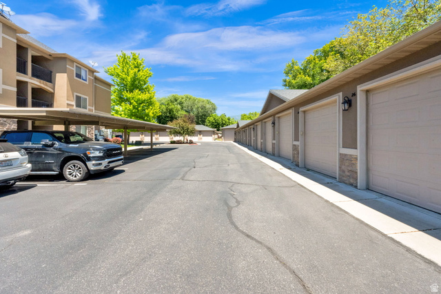 909 South Main Street, Unit G Layton, UT 84041 - Photo 24 of 25 Individual garage units featuring light-colored overhead doors, stone veneer accents, and exterior lighting fixtures