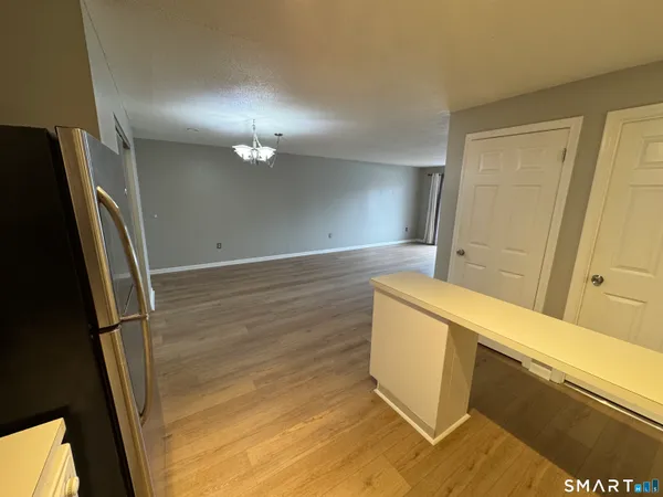 a view of a kitchen with wooden floor and a refrigerator