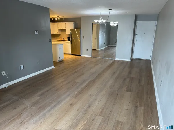 a kitchen with granite countertop stainless steel appliances a refrigerator a stove top oven and sink