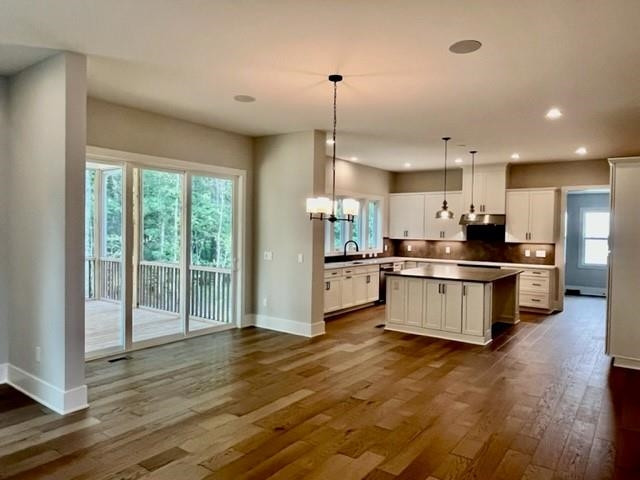 2626 Salient Apex, NC 27523 - Photo 21 of 52 a kitchen with stainless steel appliances kitchen island granite countertop a stove a sink and a refrigerator with wooden floor