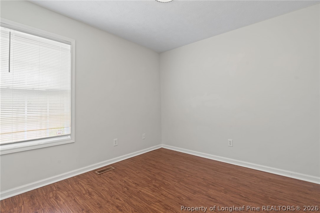 115 Shelby Street Spring Lake, NC 28390 - Photo 29 of 40 a view of an empty room with wooden floor and a window