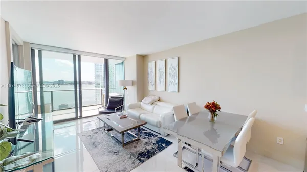 a living room with furniture and floor to ceiling windows