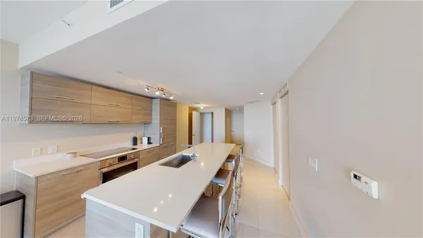 a room with a table chairs and a refrigerator