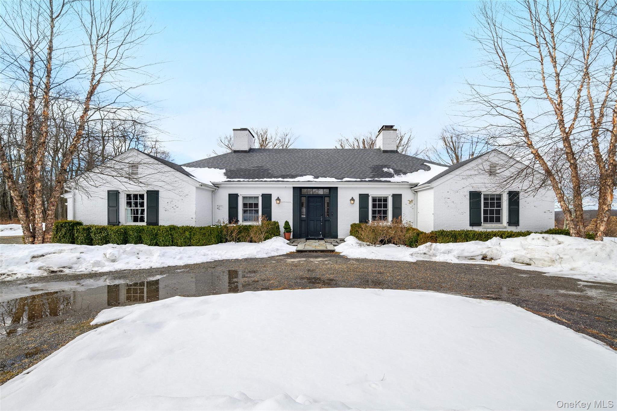 Ranch-style house featuring a chimney and brick siding