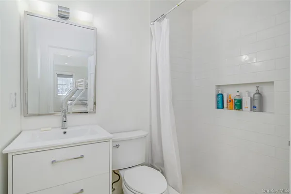 a bathroom with a toilet sink and mirror