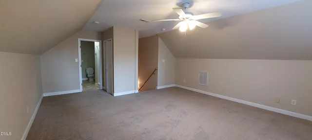 an empty room with closet and a ceiling fan