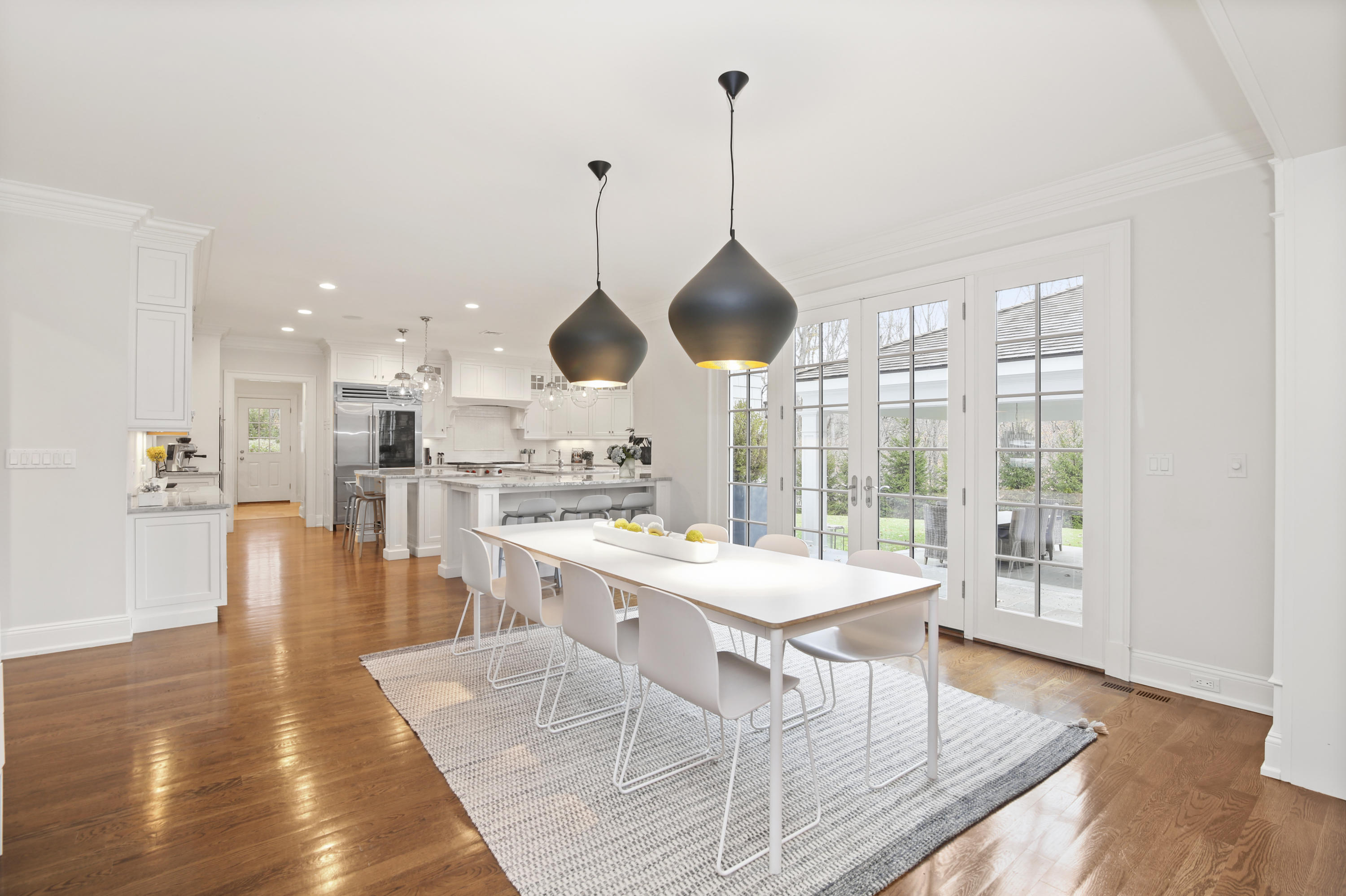 121 Chichester Road New Canaan, CT 06840 - Photo 12 of 42 a view of a dining room and livingroom with furniture wooden floor a chandelier