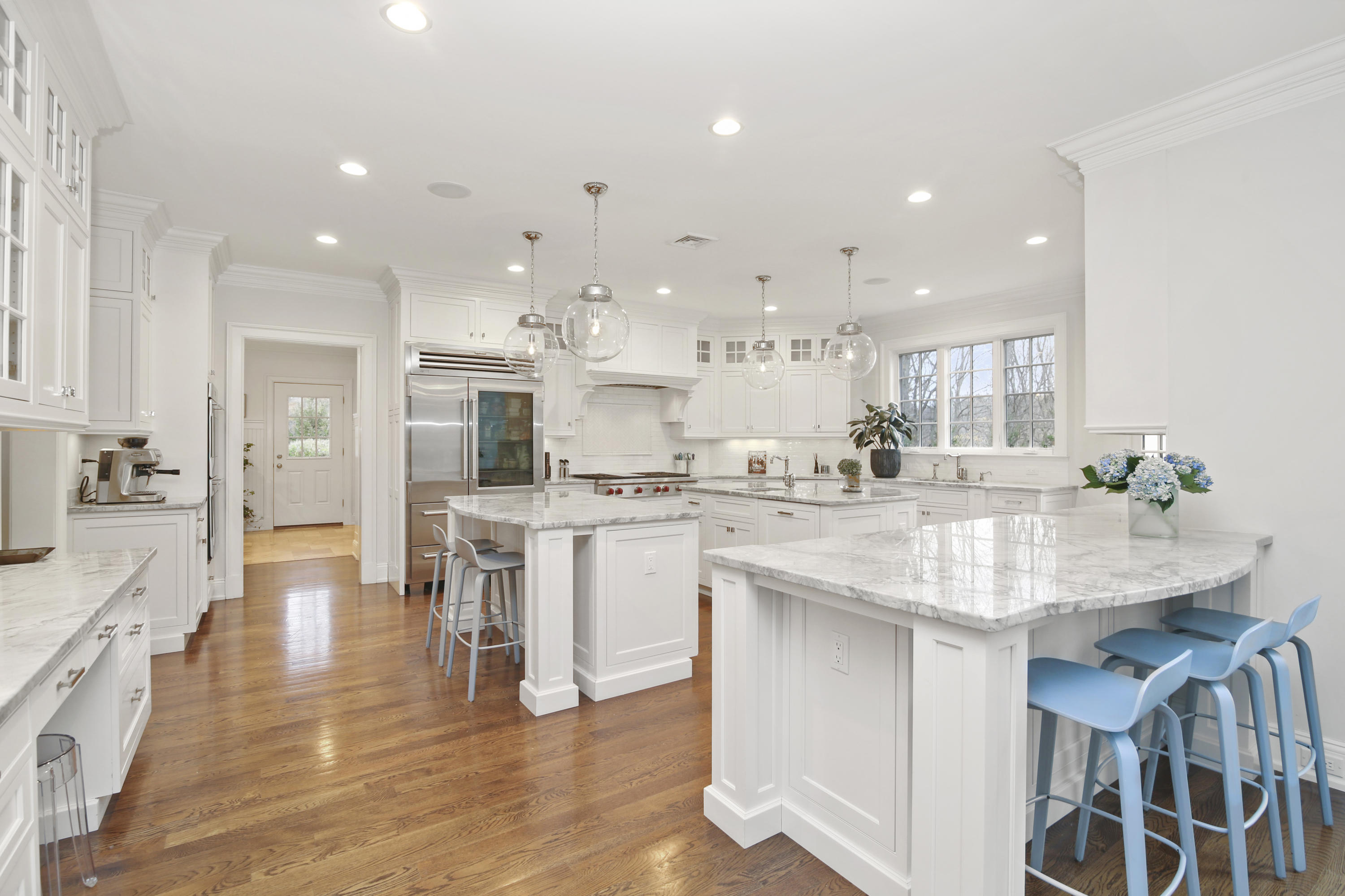 121 Chichester Road New Canaan, CT 06840 - Photo 15 of 42 a kitchen with kitchen island granite countertop a sink and white cabinets with wooden floor