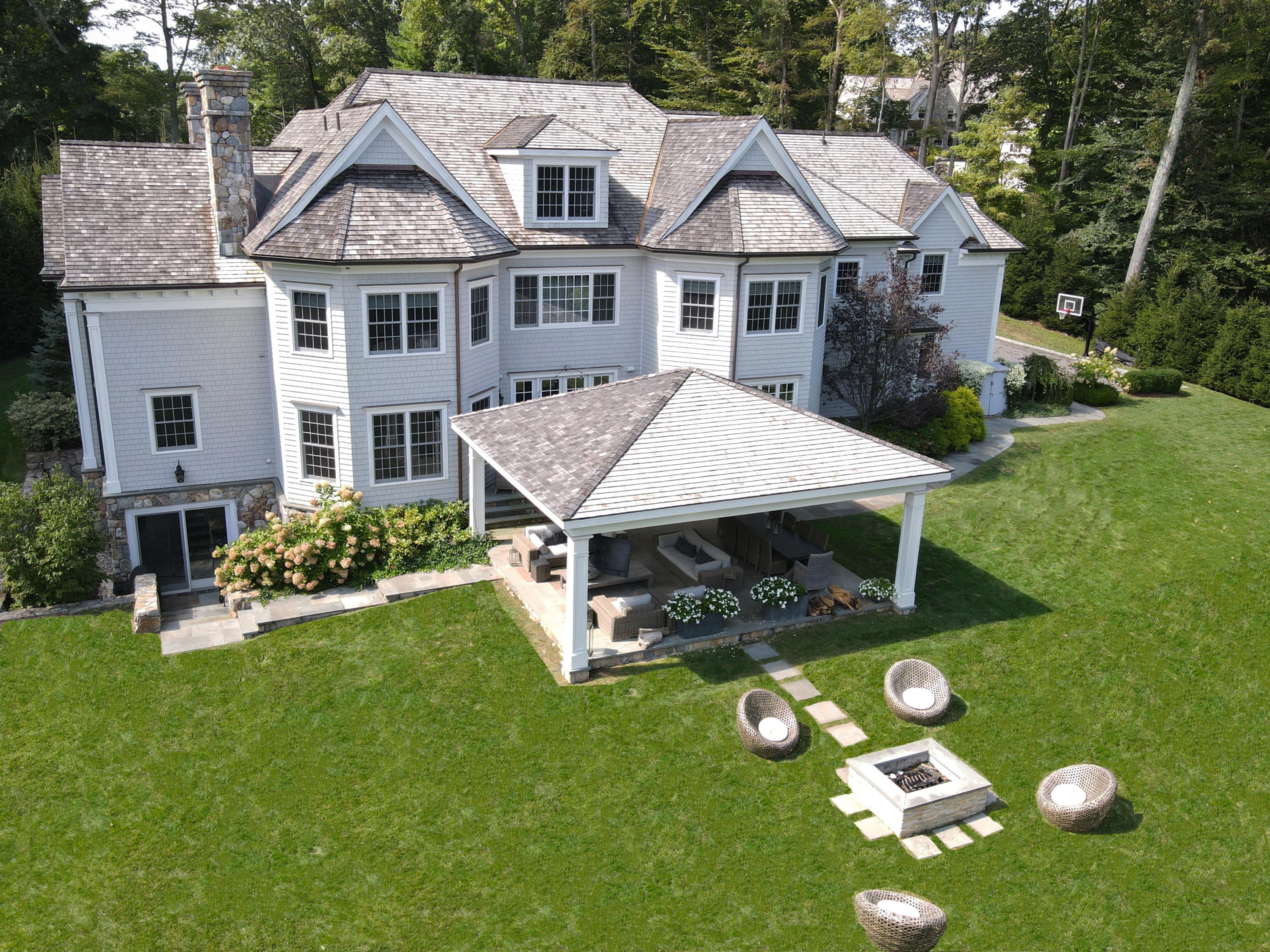 121 Chichester Road New Canaan, CT 06840 - Photo 36 of 42 a view of a white house with a yard potted plants and large tree