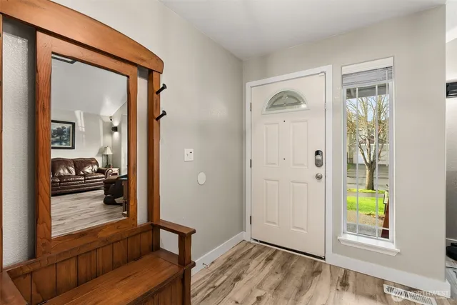 a view of a hallway with wooden floor windows and a livingroom