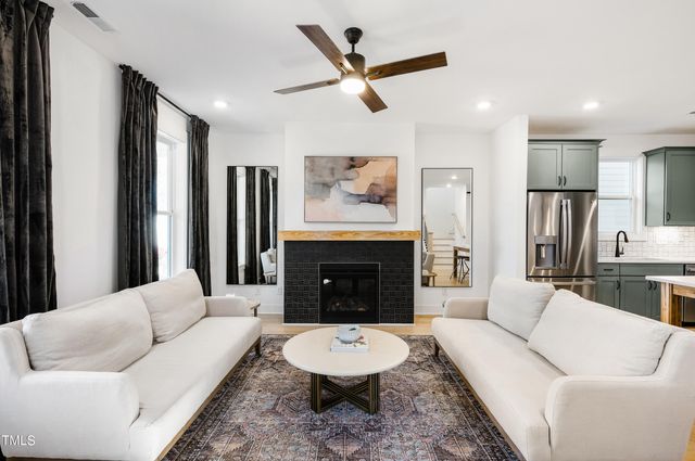a living room with furniture a fireplace and a large window
