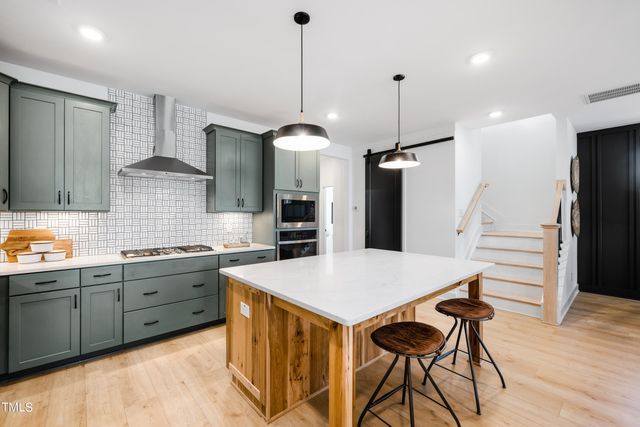 a kitchen with stainless steel appliances granite countertop a sink a stove and a microwave