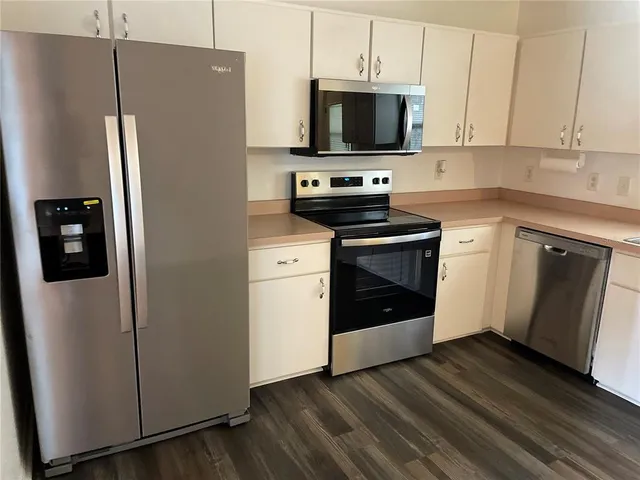 a kitchen with stainless steel appliances a refrigerator stove and microwave