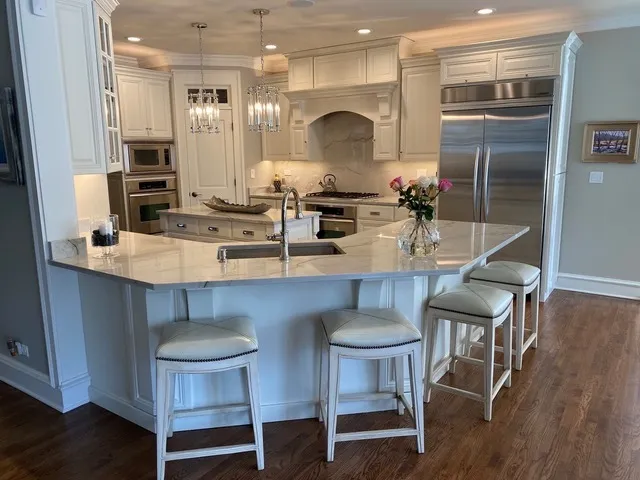 a kitchen with kitchen island granite countertop a table chairs sink and cabinets