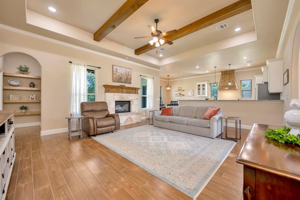 3224 North Cardinal Road Azle, TX 76020 - Photo 13 of 40 Spacious living room featuring ceramic tile flooring, a wood burning fireplace with wood mantel, and an arched built-in shelving unit
