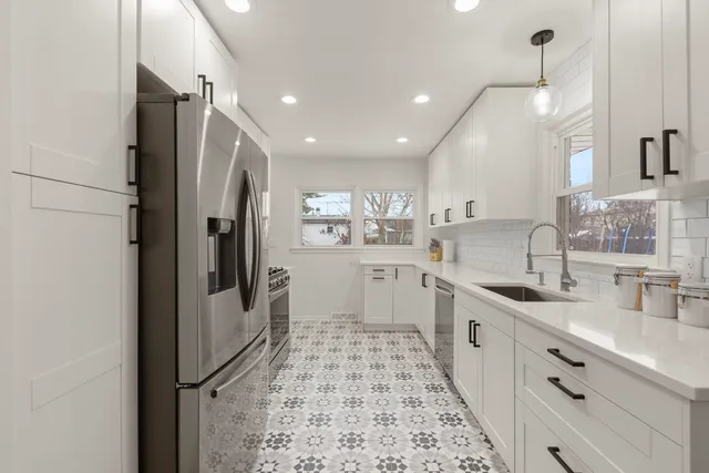 a large kitchen with a sink and refrigerator
