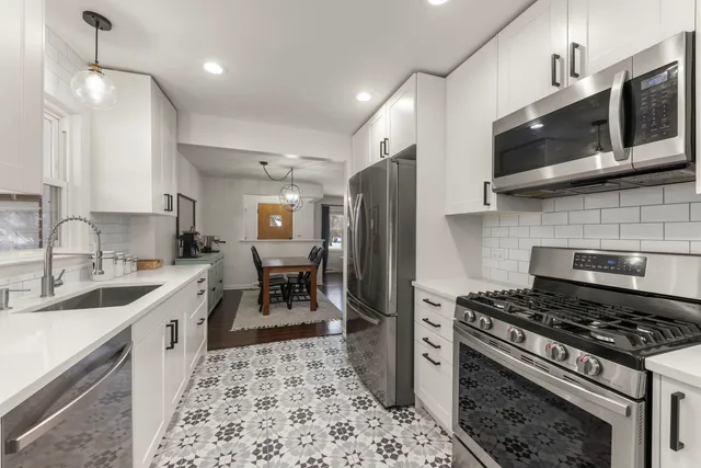 a kitchen with stainless steel appliances a stove a sink and a microwave