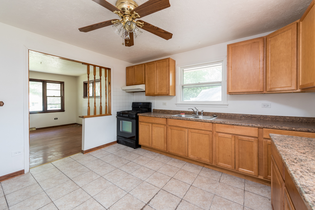 2030 Wright Avenue North Chicago, IL 60064 - Photo 5 of 10 a large kitchen with granite countertop a sink and cabinets