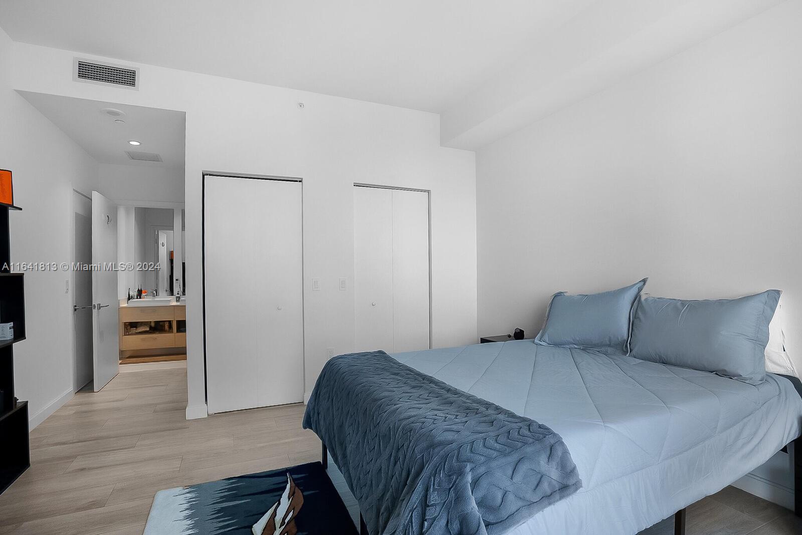 45 Southwest 9th Street, Unit 4403 Miami, FL 33130 - Photo 9 of 21 a bedroom with a bed and wooden floor