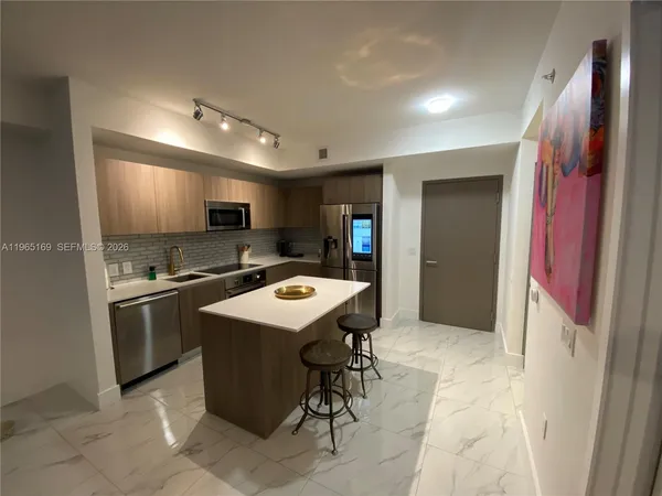 a kitchen with a sink a counter top space and stainless steel appliances