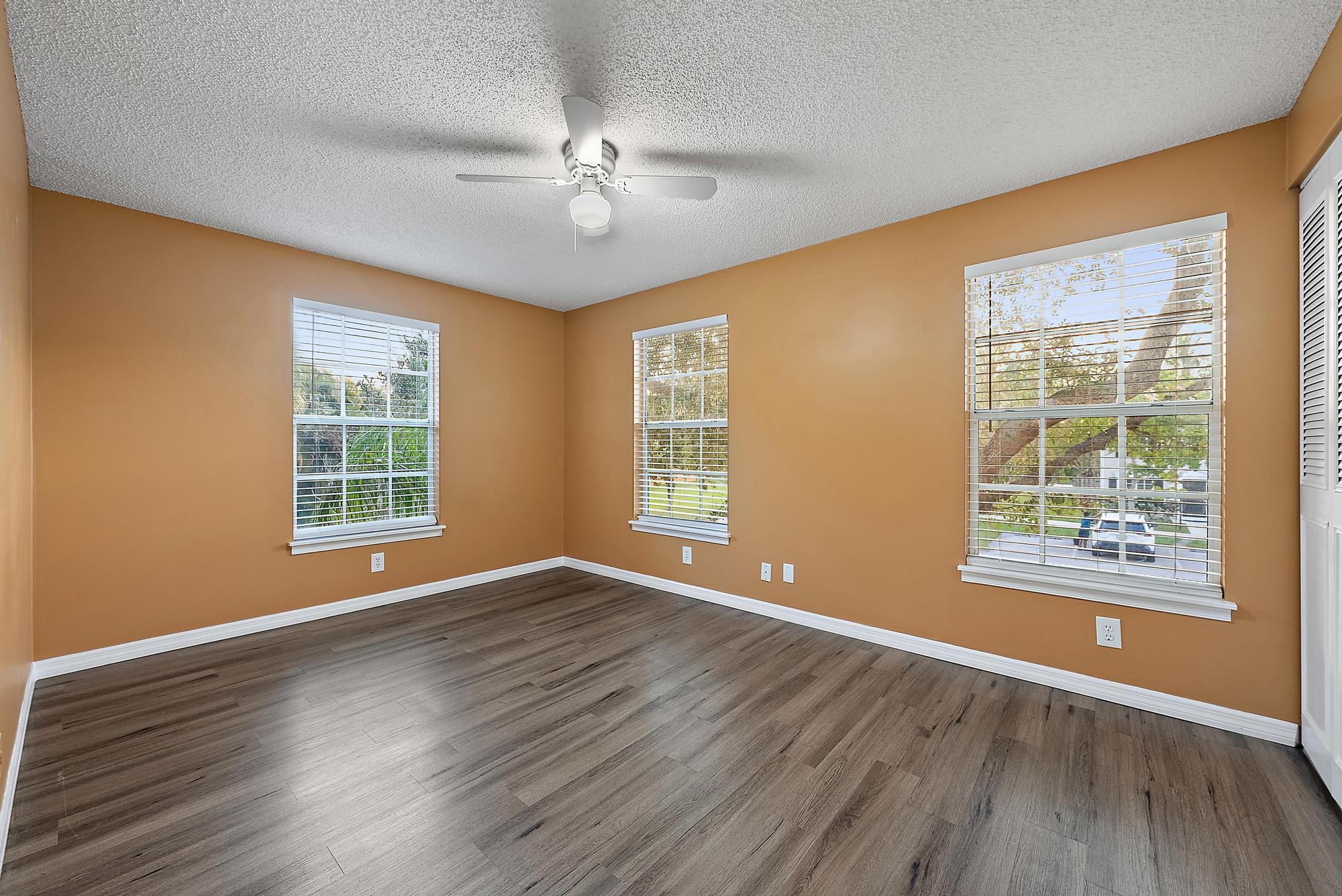 301 Georgian Park Drive Jupiter, FL 33458 - Photo 19 of 33 a view of an empty room with wooden floor and a window