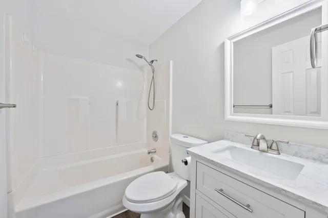 a bathroom with a granite countertop toilet a sink and a bathtub