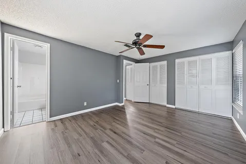 a view of room with wooden floor and ceiling fan