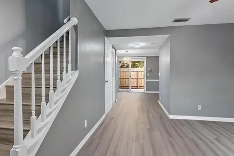 a view of a hallway with wooden floor and windows