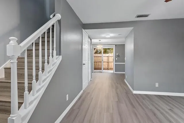 a view of a hallway with wooden floor and windows