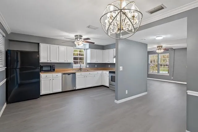 a kitchen with cabinets a window and stainless steel appliances