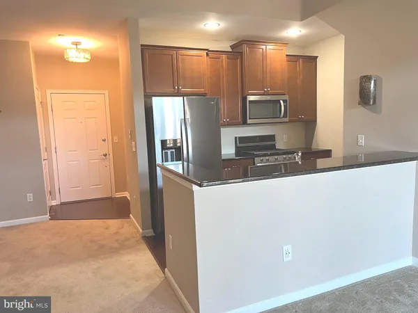 a kitchen with stainless steel appliances a refrigerator and microwave