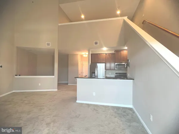 a view of a big room with wooden floor and windows