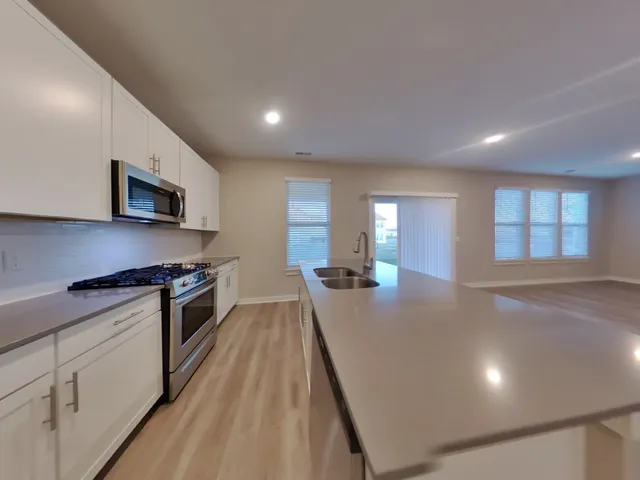 a kitchen with sink a stove and microwave