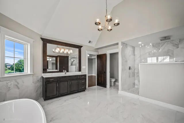 a large bathroom with a large tub and chandelier
