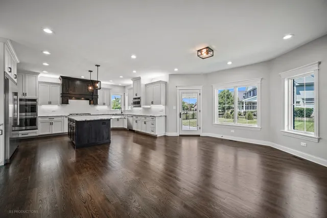 a large white kitchen with lots of counter space wooden floor and appliances