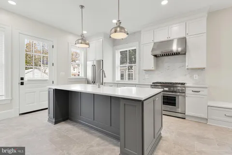 a bathroom with a double vanity sink a large mirror and a bathtub